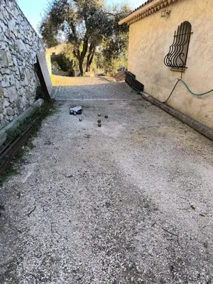 a dirt road next to a building and a wall at Maison Familiale 3 chambres Cœur de la Nature in Drap