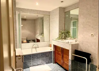 a bathroom with a tub and a sink and a mirror at 2 pièces avec clim proche place Masséna in Nice