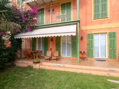 a house with a porch with a table and chairs at Le Marie Jeanne 6 Pers Giardino Vista Mare in Villefranche-sur-Mer