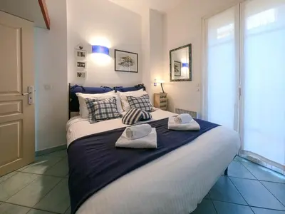 a bedroom with a large bed with towels on it at Le Marie Jeanne 6 Pers Giardino Vista Mare in Villefranche-sur-Mer