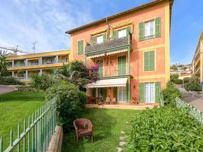 a large orange building with a fence in front of it at Le Marie Jeanne 6 Pers Giardino Vista Mare in Villefranche-sur-Mer