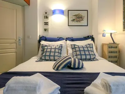 a bedroom with a bed with pillows and a blue light at Le Marie Jeanne 6 Pers Giardino Vista Mare in Villefranche-sur-Mer