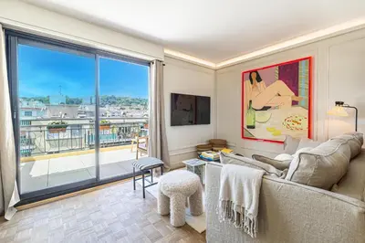 a living room with a couch and a large window at Luxurious penthouse, 2 bedroom suites, 3 spacious terraces, gorgeous views of mountains and sea, in Nice