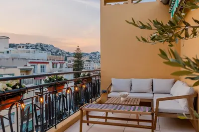 a balcony with a couch and a table at Luxurious penthouse, 2 bedroom suites, 3 spacious terraces, gorgeous views of mountains and sea, in Nice