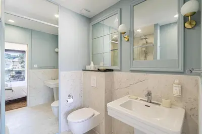 a bathroom with a sink and a toilet and a mirror at Luxurious penthouse, 2 bedroom suites, 3 spacious terraces, gorgeous views of mountains and sea, in Nice