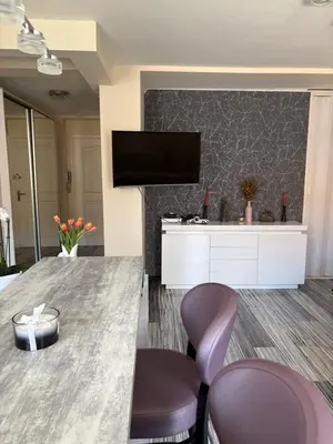 a living room with a table and two purple chairs at Elegant Apartment Terrace Port of Nice in Nice
