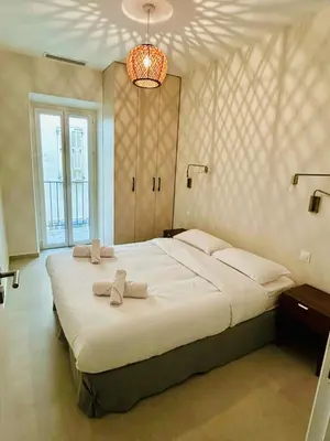 a bedroom with a large white bed with a chandelier at Charming accommodation in Port de Nice in Nice