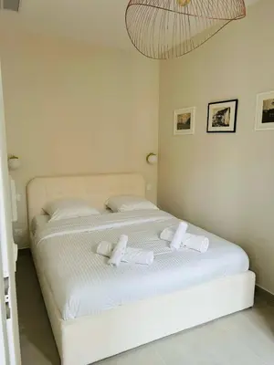 a white bed with two towels on top of it at Charming accommodation in Port de Nice in Nice