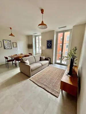 a living room with a couch and a table at Charming accommodation in Port de Nice in Nice