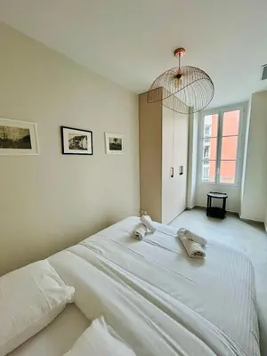 a bedroom with a large white bed with two stuffed animals on it at Charming accommodation in Port de Nice in Nice