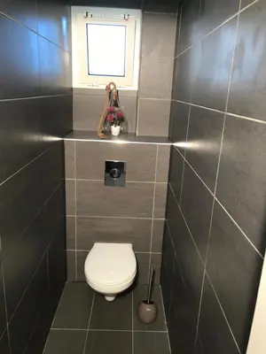 a small bathroom with a toilet and a window at Rez de jardin en bord de mer in Cagnes-sur-Mer