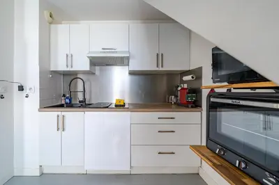 a kitchen with white cabinets and a microwave at Duplex 4 pers Port de Nice avec parking in Nice