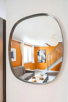 a circular mirror reflecting a living room with a couch at Duplex 4 pers Port de Nice avec parking in Nice