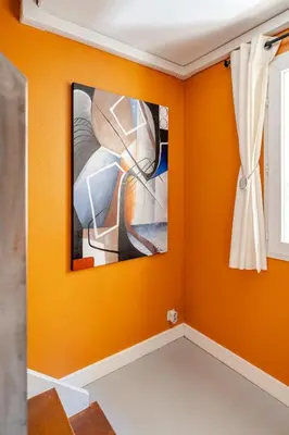 a room with orange walls and a painting on the wall at Duplex 4 pers Port de Nice avec parking in Nice