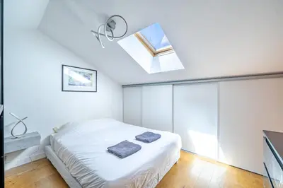 a white bedroom with a bed with a skylight at Duplex 4 pers Port de Nice avec parking in Nice