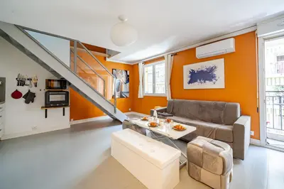 an orange living room with a couch and a table at Duplex 4 pers Port de Nice avec parking in Nice