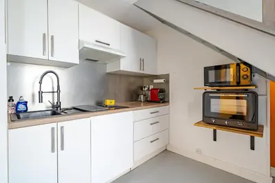 a kitchen with white cabinets and a microwave at Duplex 4 pers Port de Nice avec parking in Nice