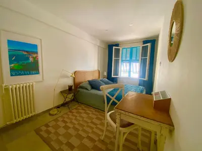 a room with a desk and a bed and a table at Au cœur du Vieux Nice, 3 chambres au calme, grand appartement in Nice