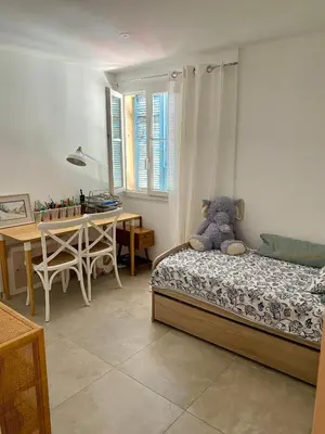 a bedroom with a bed with a teddy bear on it at Au cœur du Vieux Nice, 3 chambres au calme, grand appartement in Nice
