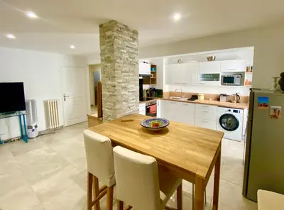 a kitchen with a wooden table and white cabinets at Au cœur du Vieux Nice, 3 chambres au calme, grand appartement in Nice