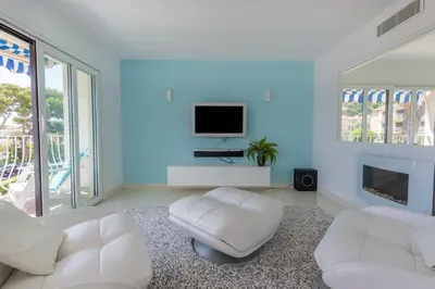a living room with white furniture and a flat screen tv at 3P ST Jean in Saint-Jean-Cap-Ferrat