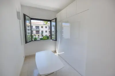 a white room with a bench and a window at 3P ST Jean in Saint-Jean-Cap-Ferrat