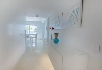 a white hallway with a table and a vase on the floor at 3P ST Jean in Saint-Jean-Cap-Ferrat