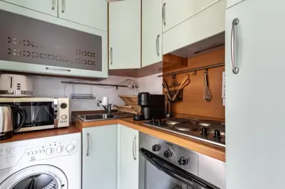a kitchen with white cabinets and a washer and dryer at HAPPYFEW Le Palais des Arts in Nice
