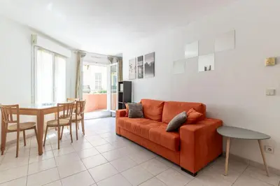 a living room with a couch and a table at HAPPYFEW Le Palais des Arts in Nice