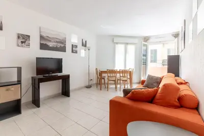 a living room with a couch and a television at HAPPYFEW Le Palais des Arts in Nice