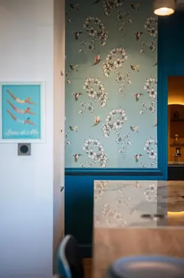 a bathroom with a blue wall with a floral wallpaper at La Fenêtre sur Mer - Superbe Vue Sur Le Port in Nice