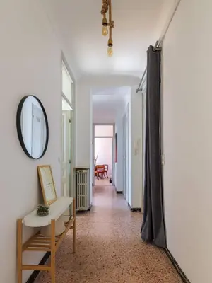 a hallway with a mirror and a chair at 3 pieces lumineux avec balcon au coeur de la ville in Nice
