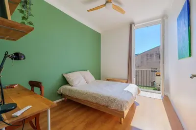 a bedroom with a bed and a desk and a window at 3 pieces lumineux avec balcon au coeur de la ville in Nice