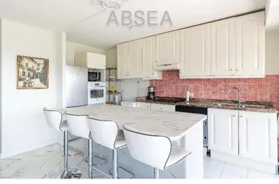 a kitchen with a marble counter top and white cabinets at Nice Absea Belles Terres 1' in Nice