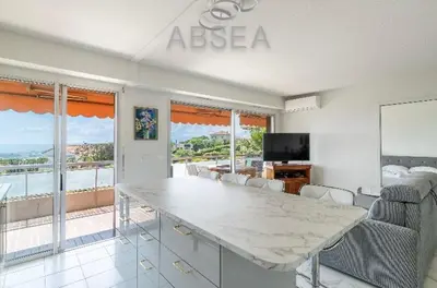 a living room with a table and a view of the ocean at Nice Absea Belles Terres 1' in Nice
