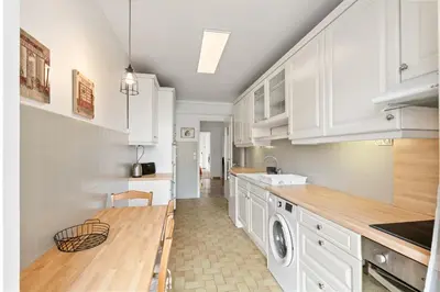 a kitchen with white cabinets and a washer and dryer at Suite de Dijon FSHH in Nice