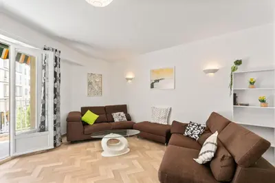 a living room with two couches and a table at Suite de Dijon FSHH in Nice