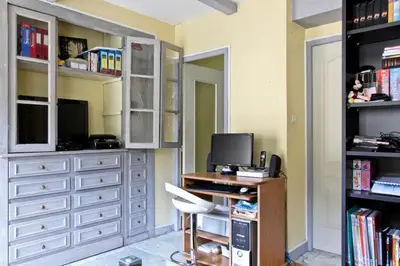 a room with a desk with a computer and a tv at Studio climatisé au calme, terrasse vue colline in Nice