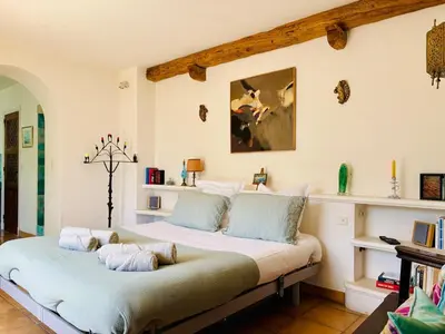 a bedroom with a large bed with pillows on it at Hacienda Provençale- Piscine, Pétanque et Plenitude in Saint-Jeannet