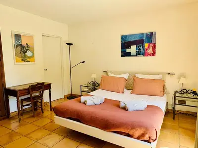 a bedroom with a large bed and a desk at Hacienda Provençale- Piscine, Pétanque et Plenitude in Saint-Jeannet
