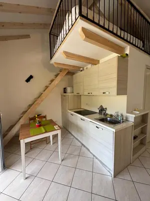 a kitchen with a sink and a table and a staircase at Apartment duplex in Eze sur Mer in Èze
