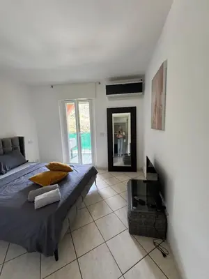 a bedroom with a bed and a person in the mirror at Apartment duplex in Eze sur Mer in Èze