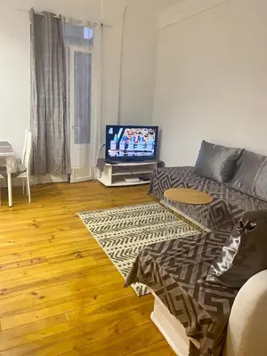 a living room with a couch and a flat screen tv at 3p proche Port in Nice