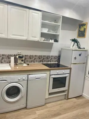 a kitchen with white cabinets and a washer and dryer at 3p proche Port in Nice
