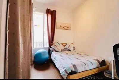 a bedroom with a bed with a blue ball next to a window at 3p proche Port in Nice