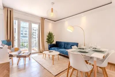 a living room with a blue couch and a table at Nice Appartement 4pers à 2 pas de la promenade in Nice