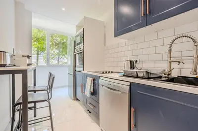 a kitchen with blue cabinets and a sink and a dishwasher at Nice Appartement 4pers à 2 pas de la promenade in Nice