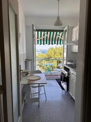 a kitchen with a table and a view of a balcony at Dolce Vita in Nice