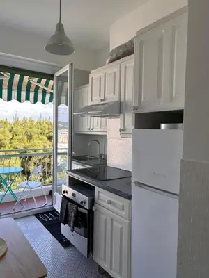 a kitchen with white cabinets and a view of a patio at Dolce Vita in Nice