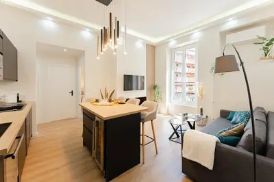 a kitchen and living room with a couch and a table at Ambiance cosy a la Niçoise in Nice